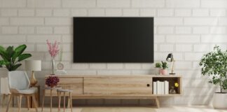 Sponsorizat: Utilitatea unei comode în amplasarea generală a camerei Mockup a TV in modern living room with armchair and plant on brick wall.